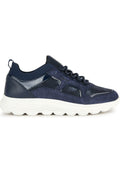 Dunkelblauer Sneaker aus einer Mischung aus Wildleder und Lackleder, ausgestattet mit einem strukturierten Strick-Bündchen am Knöchel und einer dicken weißen Gummisohle mit wellenförmigem Design.