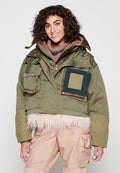 Grüne verkürzte Jacke mit einem Besatz aus Kunstfell, großen Taschen und einem Patchwork-Design in Blau und Khaki. Das Material wirkt strapazierfähig und strukturiert.