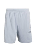 Hellblaue Sportshorts aus weichem Stoff mit elastischem Bund, seitlichen Taschen und einem grauen Adidas-Logo am unteren linken Bein.