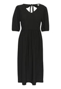 Schwarzes Midi-Kleid mit kurzen Puffärmeln, einem V-Ausschnitt und einem Bindeband auf der Rückseite. Der Stoff hat eine strukturierte Oberfläche und eine fließende Form.