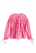 Rosa Bluse mit Puffärmeln aus glattem Stoff, mit einem gerafften Oberteil mit Kordelzug und elastischen Bündchen mit Bändern.