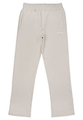 Beige Hose aus strukturiertem Stoff, mit einem elastischen Bund, zwei Seitentaschen und einem kleinen weißen Logo auf der Vorderseite.