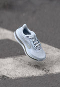 Helles blaues Sport-Schuhwerk mit Mesh-Obermaterial, weißen Schnürsenkeln und grauen Akzenten. Verfügt über eine gepolsterte Sohle und ein auffälliges Swoosh-Logo.