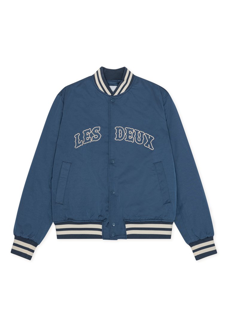 Marineblaue Bomberjacke mit weißen Streifen am Kragen und an den Bündchen. Verziert mit "LES DEUX" Stickerei und Seitentaschen. Glatter, leichter Stoff.
