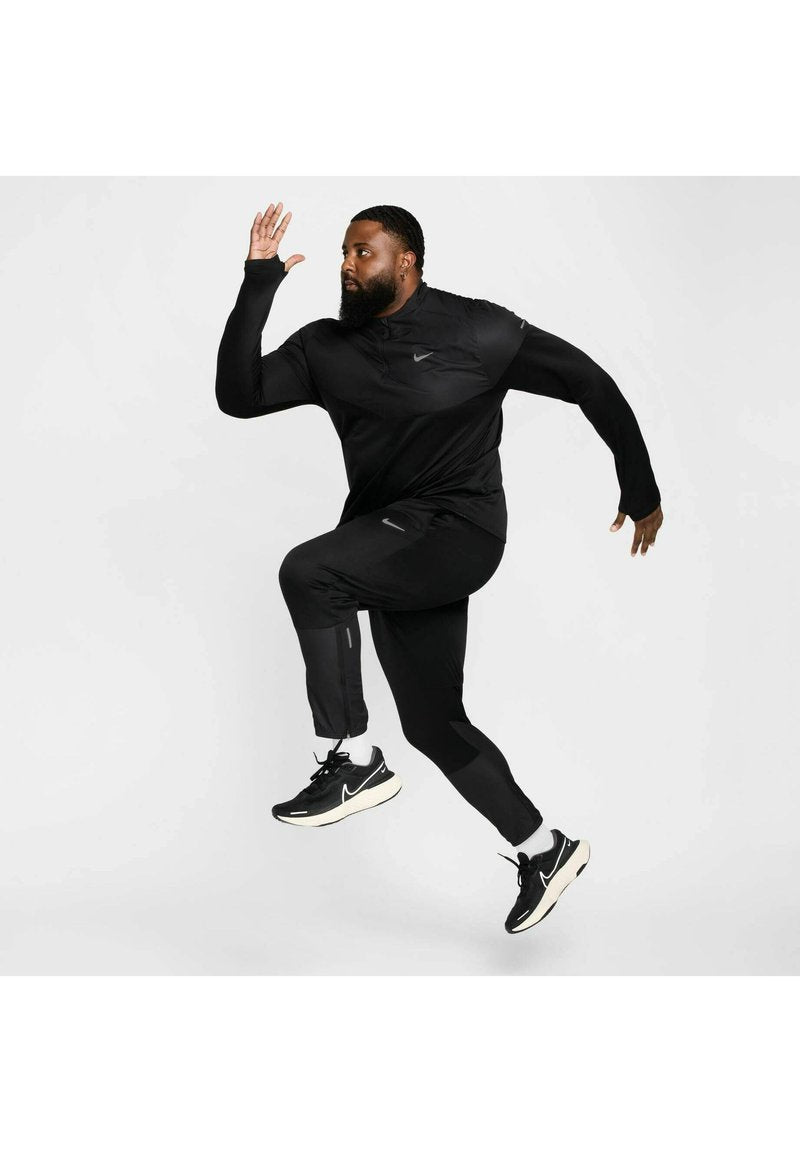 Schwarzes Sportoutfit mit einem Langarmoberteil und enganliegenden Hosen, beide mit reflektierenden Akzenten, kombiniert mit schwarzen Laufschuhen.