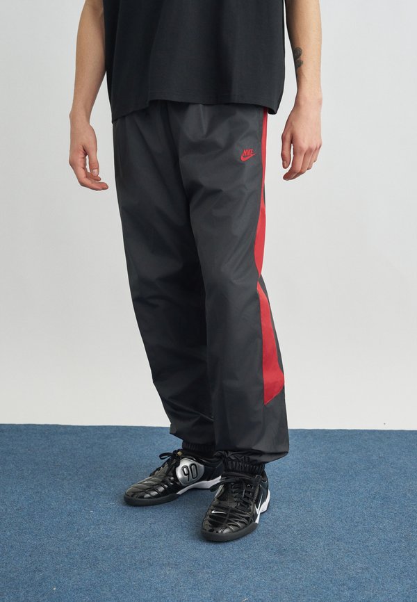 Nike Sportswear M NK WR LND PANT 26 - Tracksuit bottoms - black/team crimson