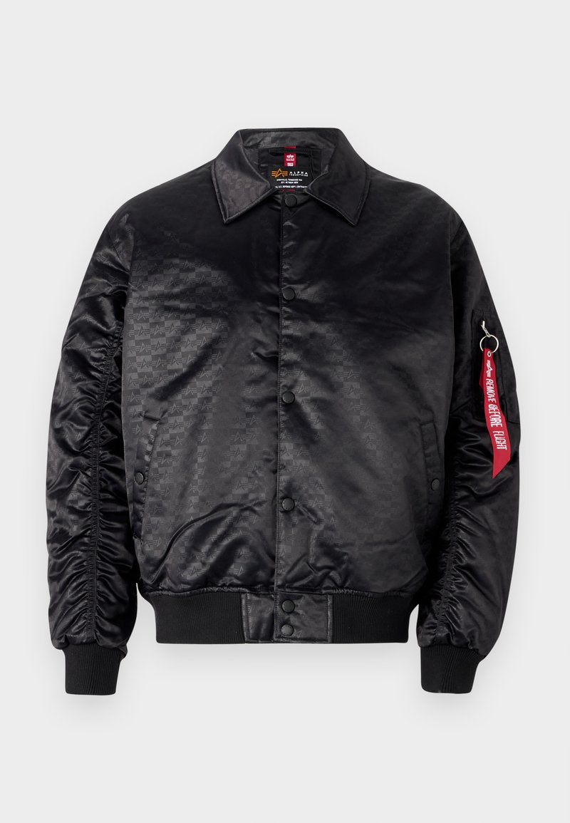 Schwarze Bomberjacke mit glatter Satin-Oberfläche, die ein dezentes Logomuster aufweist, mit gerippten Bündchen und einem roten Stoffetikett am Ärmel.