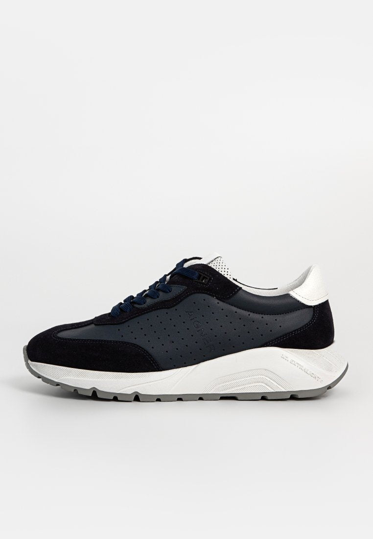Marine Sneaker aus Wildleder und Leder mit durchlöchertem Material, weißen Akzenten, blauen Schnürsenkeln und einem gepolsterten Sohlen-Design.