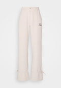 Beige Wide-Leg-Hosen mit hoher Taille, Fronttaschen, dezentem Rüschendetail am Saum und gesticktem Logo in Dunkelbraun.