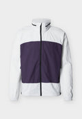 Weiße Jacke mit violettem Brustbereich, hohem Kragen, durchgehendem schwarzen Frontreißverschluss und elastischen Bündchen an den Ärmeln.