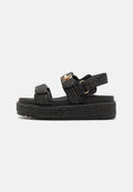 Schwarze Plateausandalen mit geflochtenen Riemen, verstellbaren Schnallen und einer dicken strukturierten Sohle für Griff und Stabilität. Minimalistisches Design.