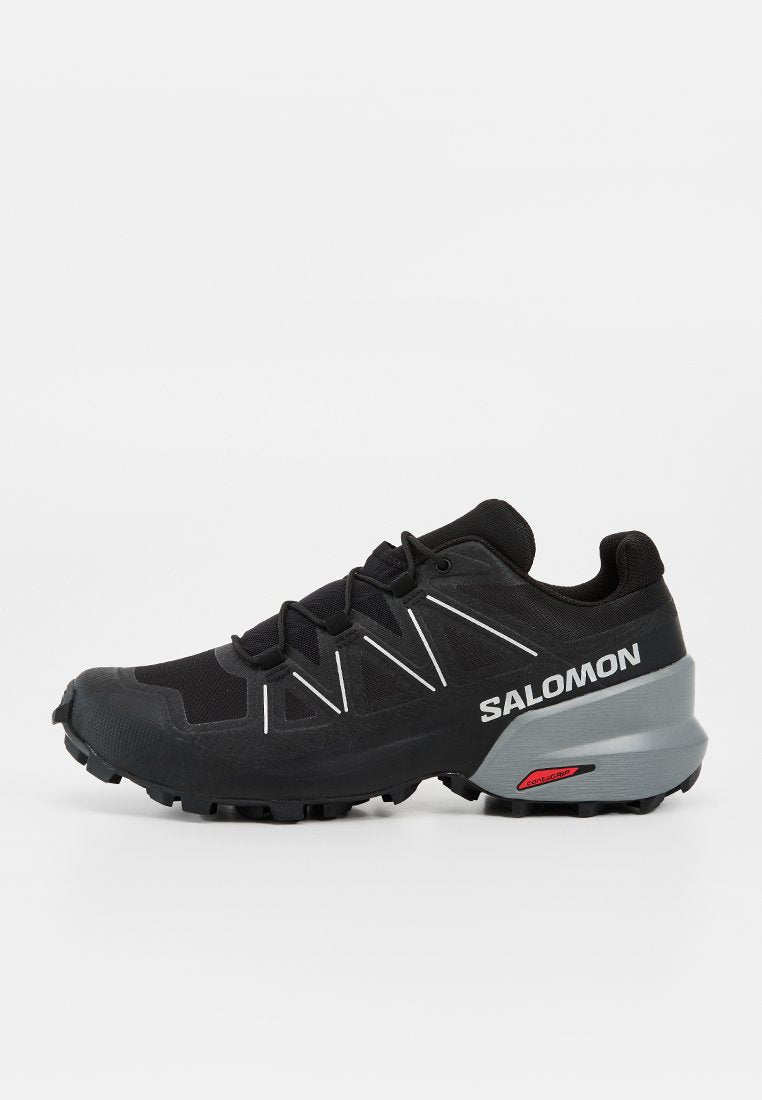 Schwarzer Salomon Trailrunning-Schuh mit robustem Profil, weißem Logo an der Seite, verstärkter Zehenkappe und grauem Fersenbereich mit rotem Contagrip-Label.