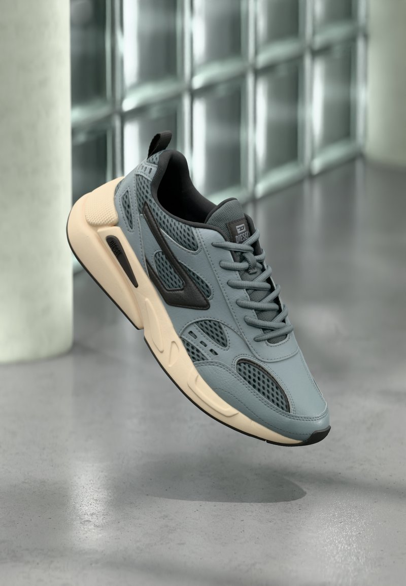Hellgraue Sneakers aus Mesh und Leder mit schwarzen Akzenten und cremefarbener Sohle. Verfügt über eine abgerundete Spitze, Schnürdesign und eine Zuglasche hinten.