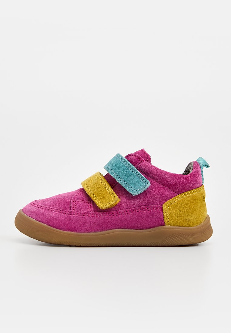 Kinderschuh aus rosa Wildleder mit gelben und türkisfarbenen Klettverschlüssen, gelber Fersenlasche und brauner Gummisohle auf weißem Hintergrund.