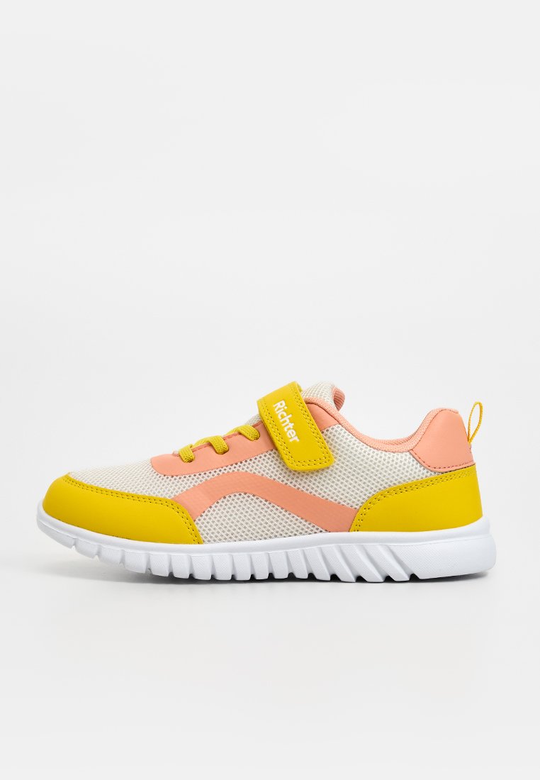 Kindersneaker aus weißem Mesh mit gelber Schuhspitze, Ferse, Schnürsenkeln und Riemen, pinken Akzenten und weißer Sohle, Seitenansicht nach links gerichtet.
