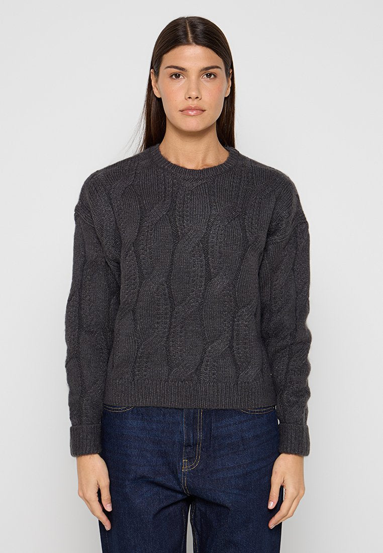 Dunkelgrauer, kabelgestrickter Pullover mit rundem Ausschnitt, gerippten Bündchen und Saum sowie einem strukturierten Muster. Kombiniert mit blauen Jeans.