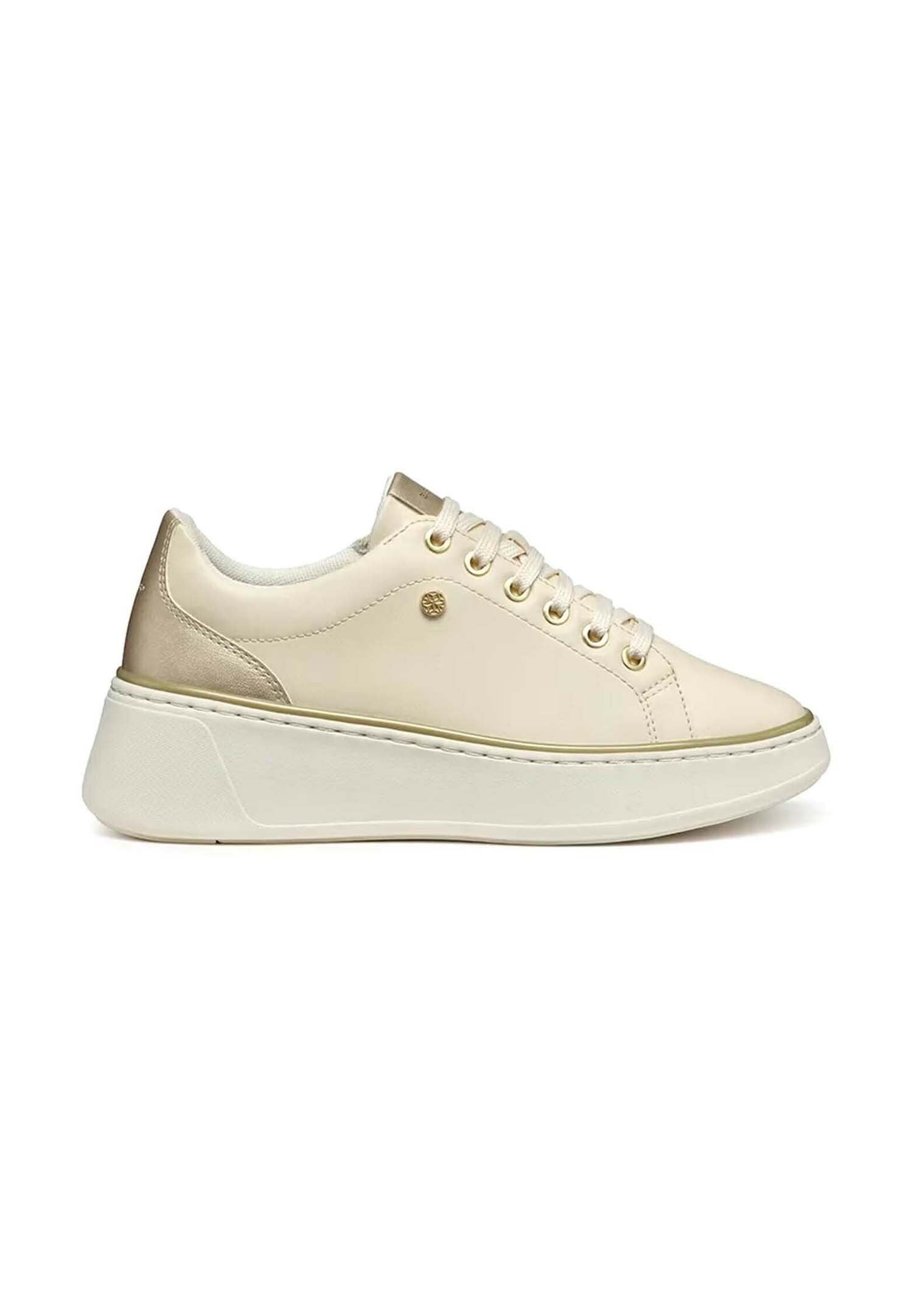 Beiger Sneaker mit glattem Lederobermaterial, metallischen Akzenten, abgerundeter Spitze, goldenen Ösen und dicker weißer Sohle.