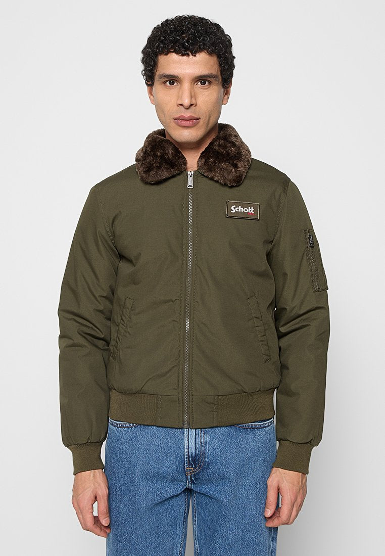Fliegerjacke in olivgrün mit Kunstpelzkragen, Reißverschluss vorne, elastischen Bündchen und Saum sowie Seitentaschen; mit Markenaufnäher auf der Brust.