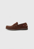 Braune Wildleder Slipper mit runder Zehe, genähten Details entlang der Kante und Gummisohle. Besitzt ein kleines Markenetikett an der Seite.