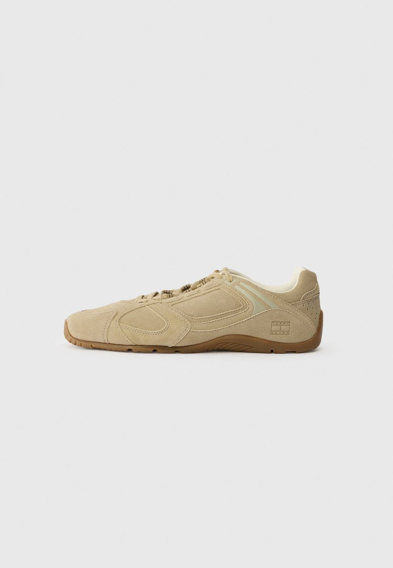 Beige Sportschuh mit einem strukturierten Wildleder-Obermaterial, Gummisohle und minimalistischen Designelementen. Mit elastischen Schnürsenkeln und dezenten Logo-Details.