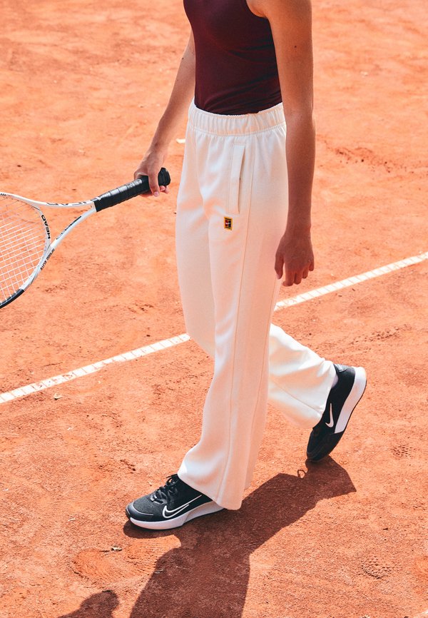 Nike Performance NIKECOURT PANT HERITAGE - Tracksuit bottoms - pale ivory