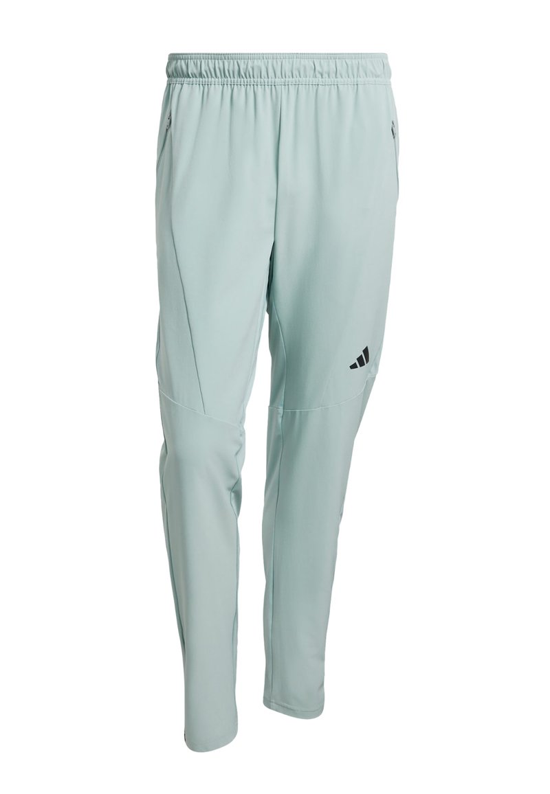 Hellgrüne Sporthose mit elastischem Bund, zulaufenden Beinen, Seitentaschen und einem schwarzen Logo am linken Oberschenkel. Weicher, dehnbarer Stoff.