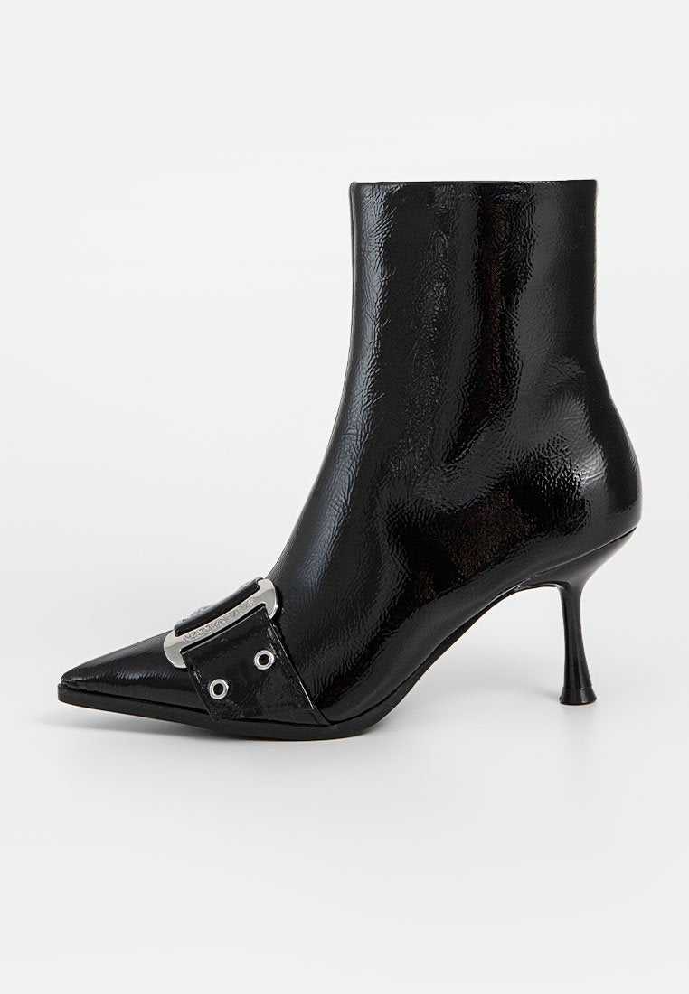 Schwarze Lackleder-Stiefelette mit spitzem Zehenbereich, metallischem Schnallendetail und dünnem hohen Absatz. Glatte Textur mit glänzender Oberfläche.