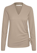 Beige Langarmshirt mit V-Ausschnitt und gerafftem Seitendetail. Hergestellt aus weichem Stoff mit glatter Textur und verstellbarem Band in der Taille.