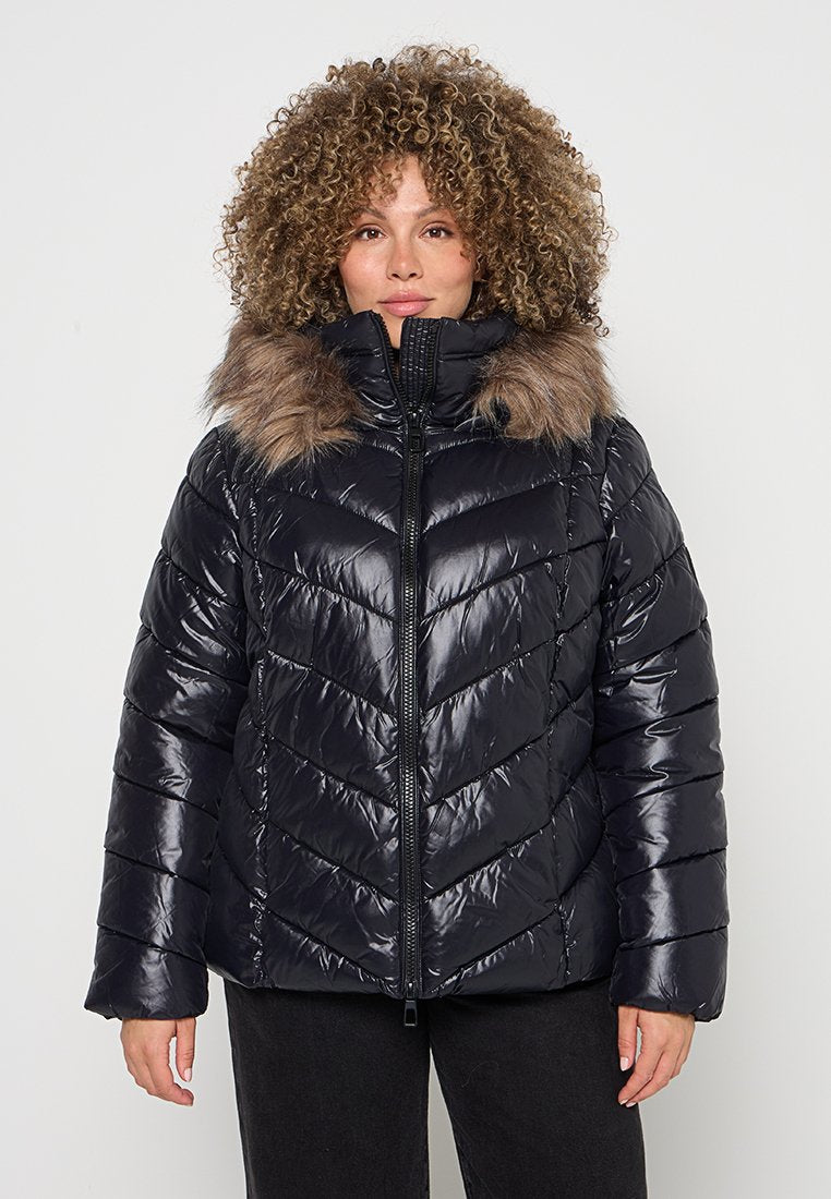 Schwarze Steppjacke mit einem gesteppten Chevron-Muster, ausgestattet mit einem hohen Kragen und Kunstpelzbesatz rund um die Kapuze. Vorderer Reißverschluss.