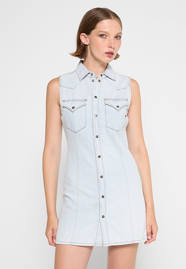 Denimkleid mit ärmellosem Design, hellblauer Farbe, durchgehender Knopfleiste, zwei Brusttaschen und kontrastierenden Nähdetails.