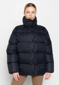 Marineblaues Steppjacke mit hohem Kragen, ausgestattet mit einem gesteppten Design und Knopfverschlüssen, hergestellt aus einem glänzenden, isolierenden Stoff.