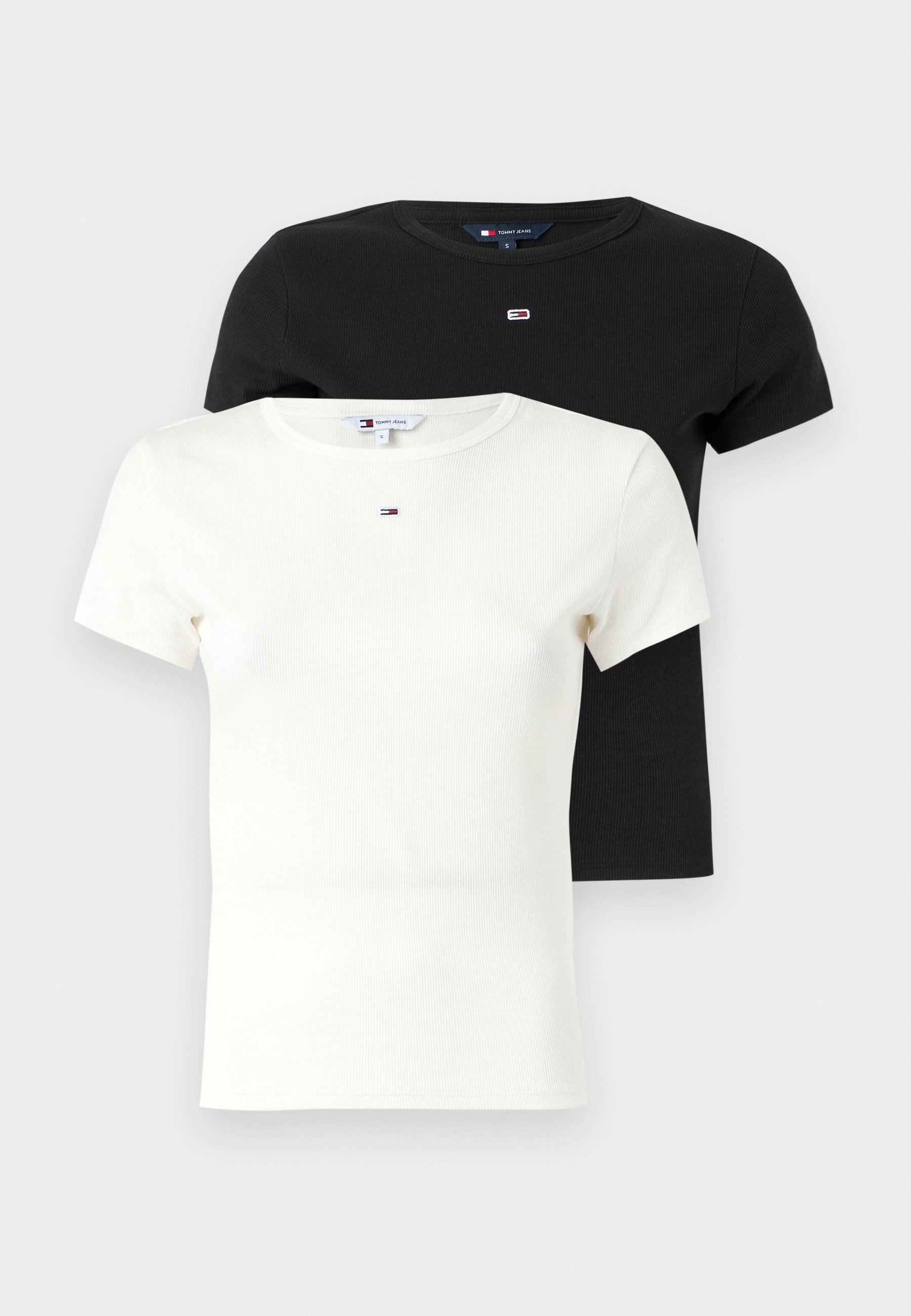 Zwei kurzärmlige T-Shirts übereinander gestapelt, eines in Schwarz und eines in Weiß, mit einer gerippten Textur und einem kleinen Logo auf der Brust.