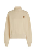 Beige Rollkragen-Sweatshirt aus weichem Stoff, mit einem lockeren Schnitt, überschnittenen Schultern und einem kleinen runden Logo auf der Brust.