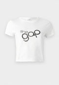 Weißes, kurz geschnittenes T-Shirt aus Baumwolle mit einem schwarzen Glitzer-Logo "the gap" auf der Vorderseite. Kurze Ärmel und runder Ausschnitt.