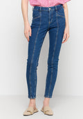 High-Waist blaue Skinny-Jeans aus Denim mit Vordertaschen und weißen Ziernähten, kombiniert mit beigen Slippern.