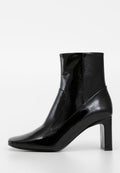 Schwarze Knöchelstiefel aus glänzendem synthetischem Material mit strukturierter Oberfläche, spitzem Zehenbereich und quadratischem hohen Absatz. Stilvolles Design ohne sichtbare Beschläge.