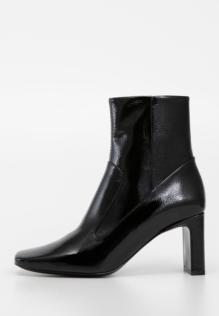 Schwarze Knöchelstiefel aus glänzendem synthetischem Material mit strukturierter Oberfläche, spitzem Zehenbereich und quadratischem hohen Absatz. Stilvolles Design ohne sichtbare Beschläge.