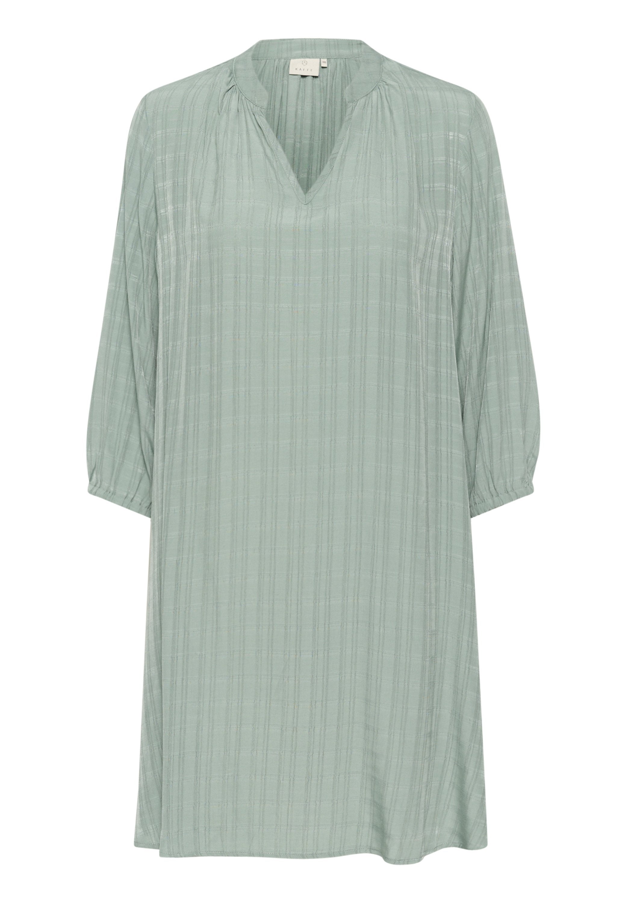 Hellgrünes Tunika-Kleid aus strukturiertem Stoff, mit V-Ausschnitt, drei Viertelärmeln und vertikalem Streifenmuster.
