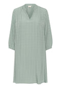 Hellgrünes Tunika-Kleid aus strukturiertem Stoff, mit V-Ausschnitt, drei Viertelärmeln und vertikalem Streifenmuster.