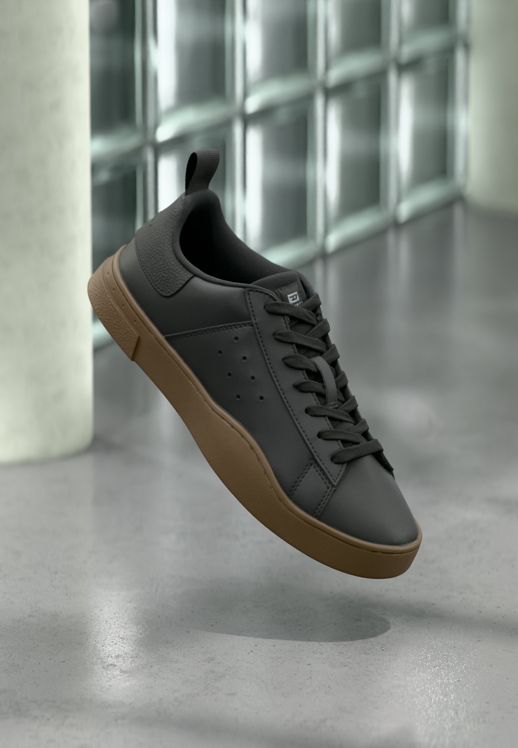 Schwarze Leder-Sneaker mit strukturierter Rückseite, brauner Gummisohle, abgerundeter Zehenpartie und flachen Schnürsenkeln; mit seitlichen Perforationen für Atmungsaktivität.