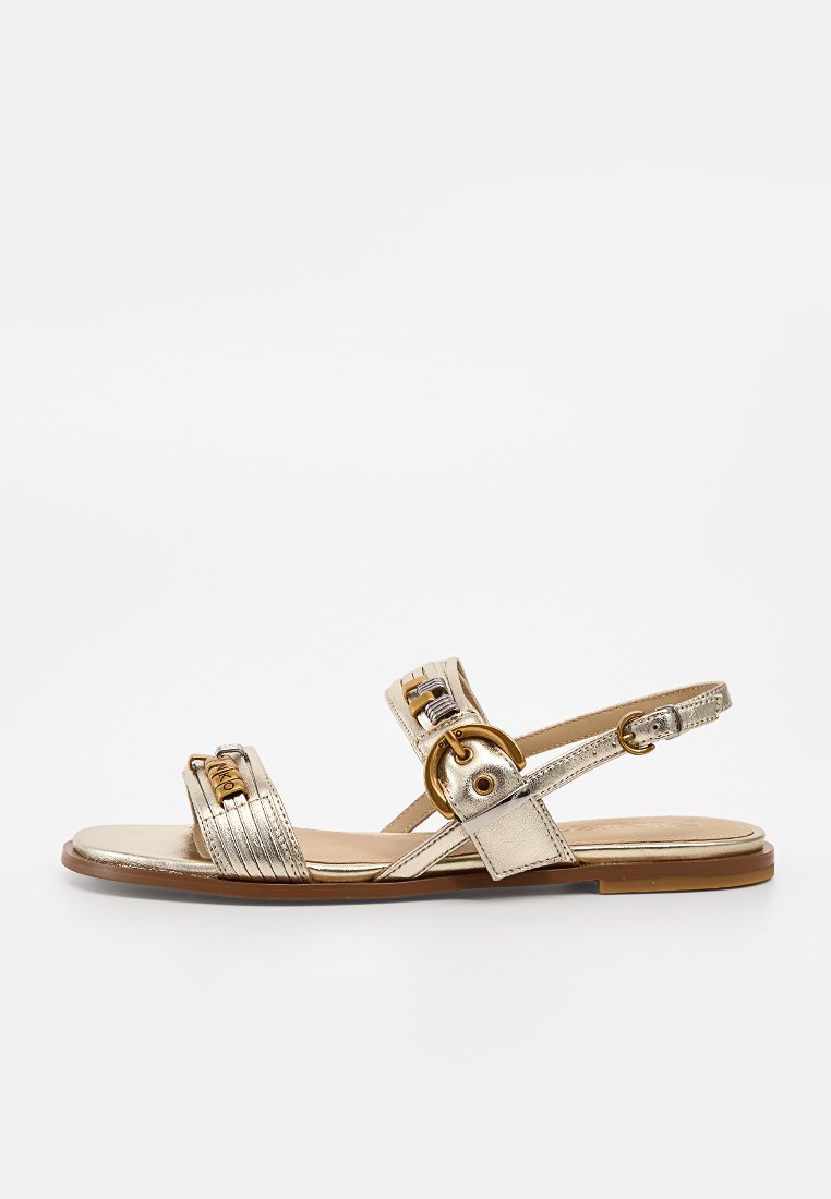 Goldene flache Sandale mit offener Spitze, zwei vorderen Riemen mit goldfarbener Hardware, Knöchelriemen mit runder Schnalle und niedriger brauner Sohle.