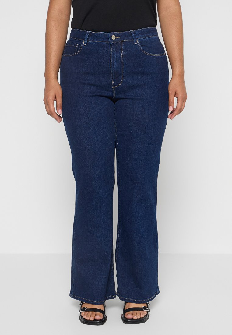 Dunkelblaue, ausgestellte Jeans aus Denim mit hoher Taille, fünf Taschen, dezentem Steppdetail und leichtem Struktur. Mit einem Knopfverschluss akzentuiert.