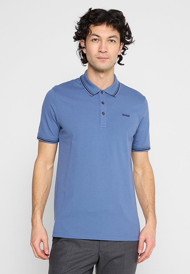 Blaues Poloshirt mit klassischem Kragen, zwei Knöpfen, kontrastierenden dunkel gestreiften am Kragen und an den Ärmeln sowie einem kleinen Markenlogo.