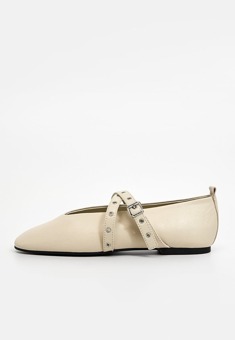 Beige Lederflats mit spitzem Zehenbereich und breitem Einstieg. Verfügt über einen dekorativen Riemen mit silberfarbener Hardware und runden Ausschnitten.