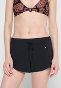 Schwarze Badeshorts mit abgerundetem Saum, elastischem Bund und Kordelzugverschluss. Hergestellt aus leichtem Material mit schlichter Gestaltung.