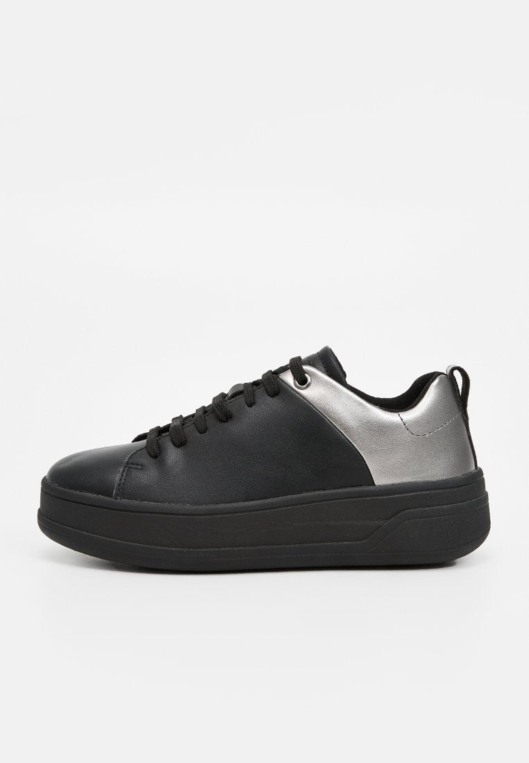Schwarze Ledersneaker mit silbernem Metallic-Akzent, runder Zehenform, schwarzen Schnürsenkeln und einer dicken schwarzen Laufsohle, die minimalistische Designelemente aufweist.