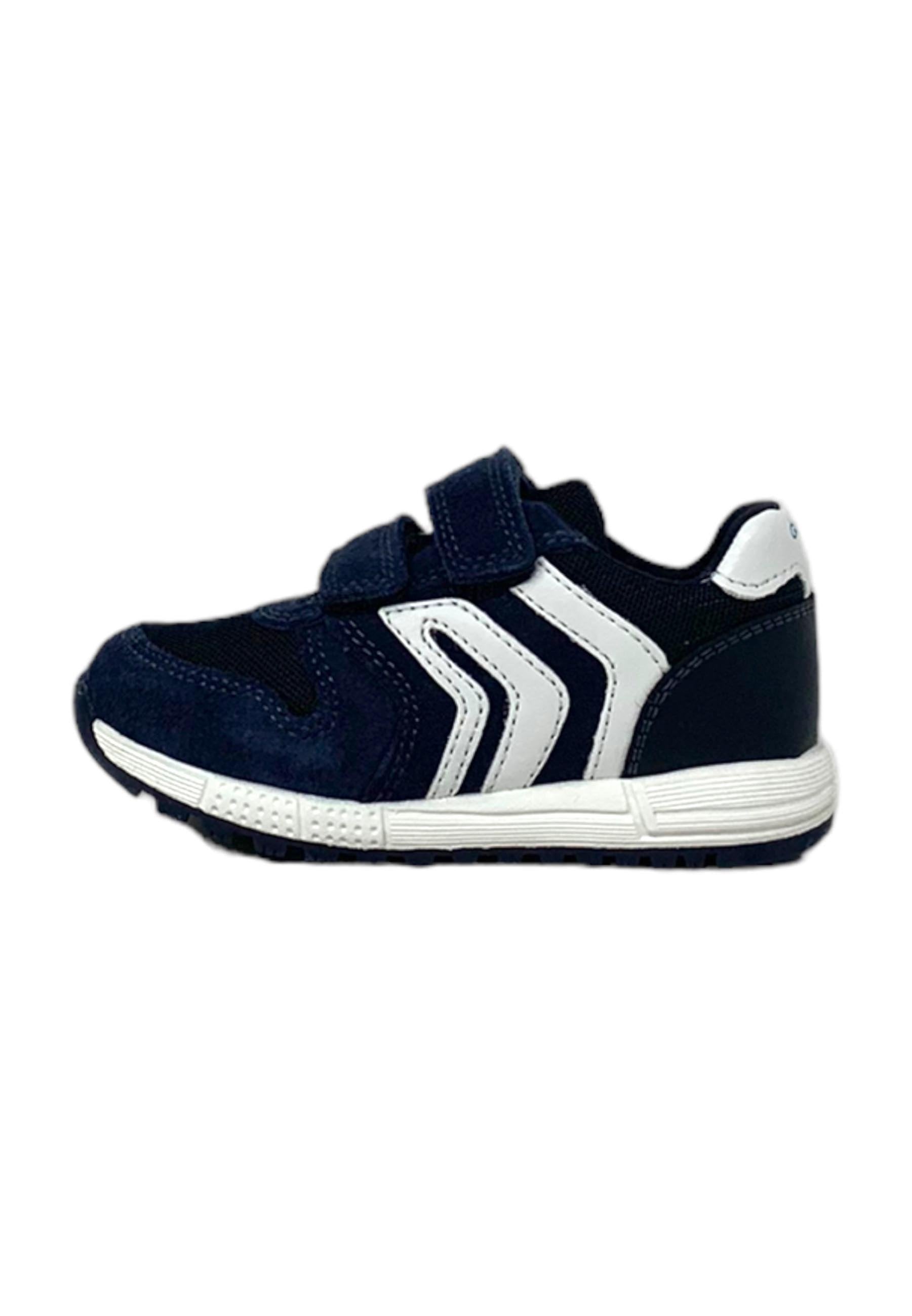 Marineblaue Sportschuhe mit weißen Akzenten, Klettverschluss, aus Wildleder und Mesh-Material, texturiertem Profil und aerodynamischem Design.