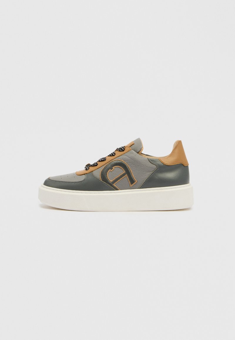 Niedriger Sneaker aus grauem, dunkelgrünem und beigem Leder mit schwarzen gemusterten Schnürsenkeln und weißer, dicker Gummisohle, Seitenansicht.