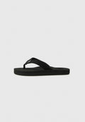 Schwarze Flip-Flop-Sandale mit dicken Stoffriemen und flacher gepolsterter Sohle, seitlich auf einem schlichten weißen Hintergrund präsentiert.