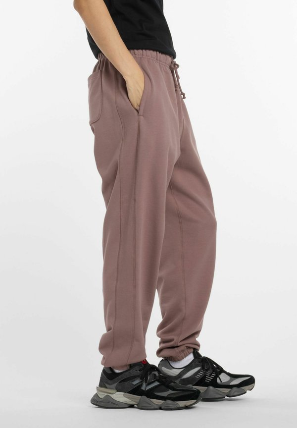 New Balance ATHLETICS - Tracksuit bottoms - earth shadow